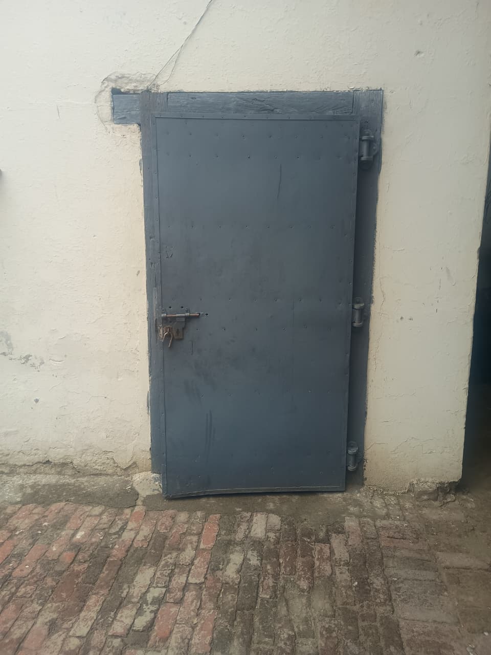 Secure grey metal access door with padlock at cold storage facility