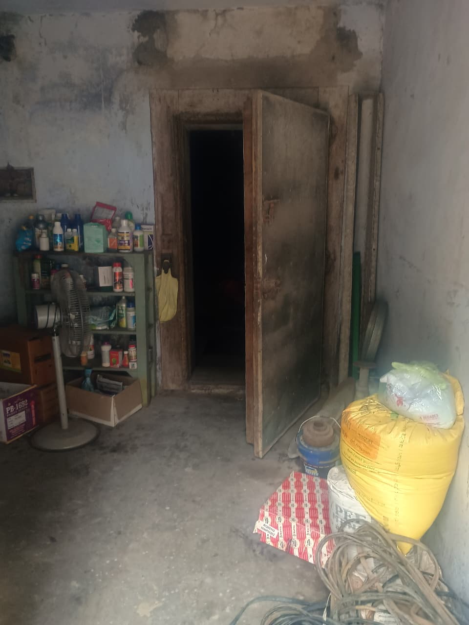 Storage room with chemical and supplies shelf, wooden door entry