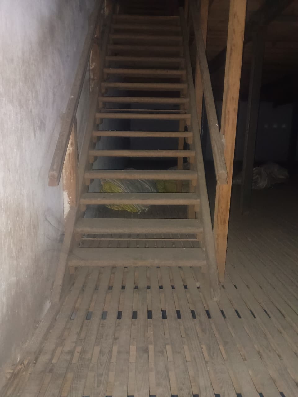 Second wooden staircase with green tarpaulin visible — cold storage access